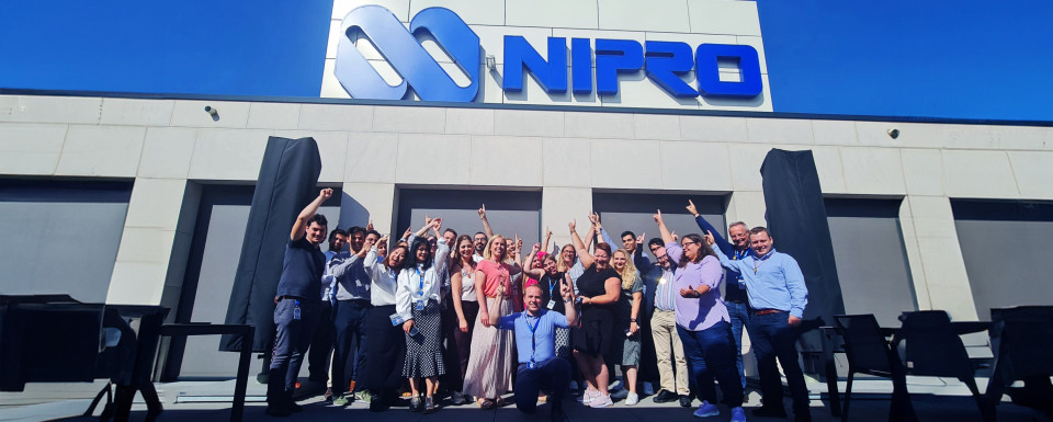 Employees pointing at Nipro logo