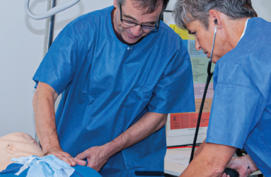 2 nurses simulating a training with a dummy 